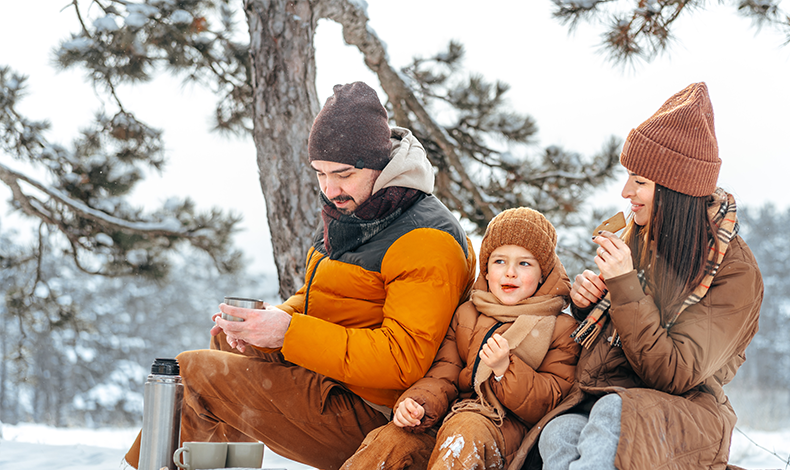 family enjoying snacks and cocoa in the winter