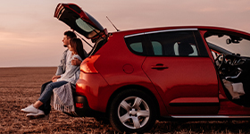Couple sitting on back of car